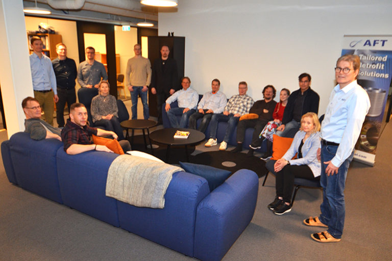 Office space with a many co-workers sitting on a sofa