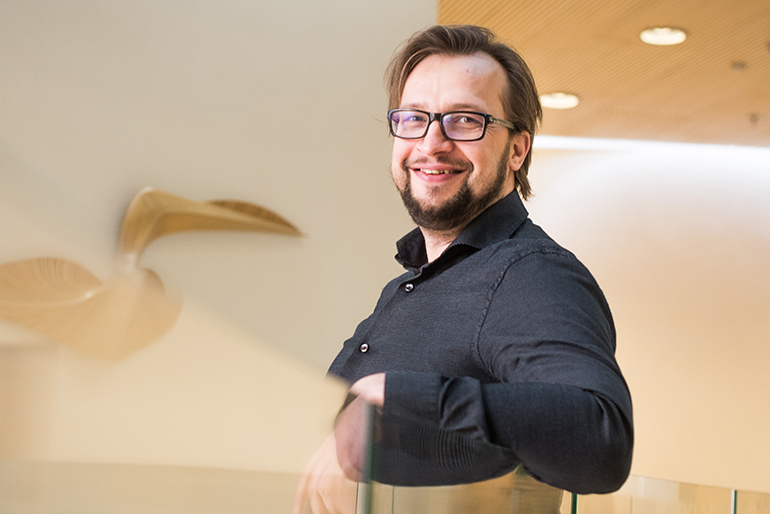 Joni Salmi katsoo kohti kameraa ja hymyilee.