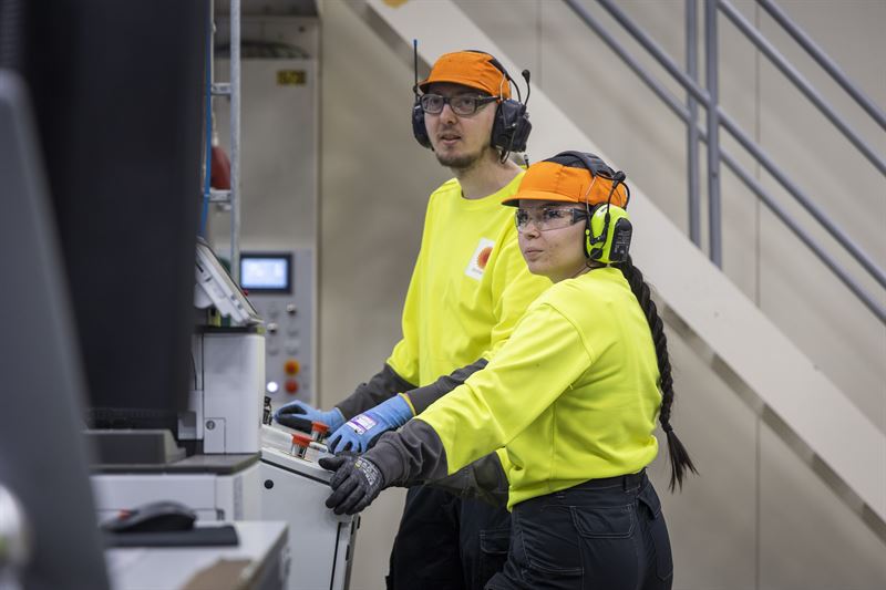 Mies ja nainen valvovat Stora Enson tehtaalla tuotantolinjaa.
