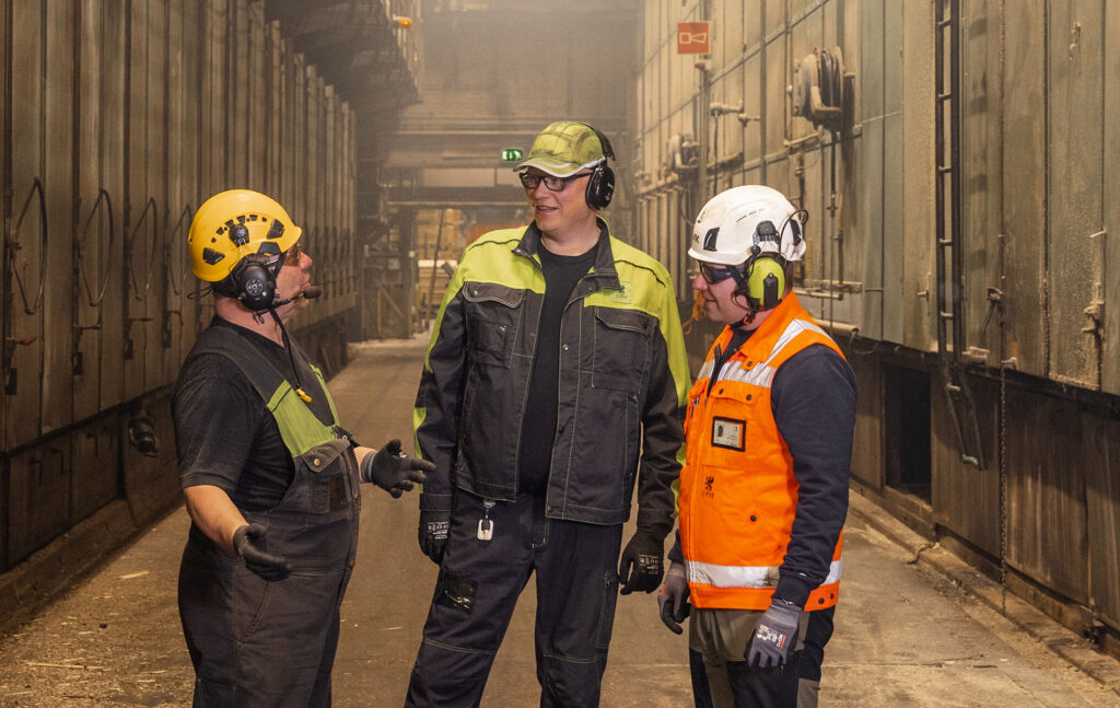 Jarno Koivumäki (vas.), Juhana Hirn ja Mikko Syrjäläinen juttelevat puun kuivureiden välisellä käytävällä.