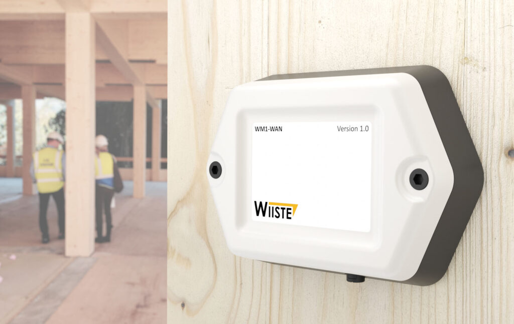 Wiiste-nimisen yrityksen kosteudenhallintamittari seinälle kiinnitettynä.